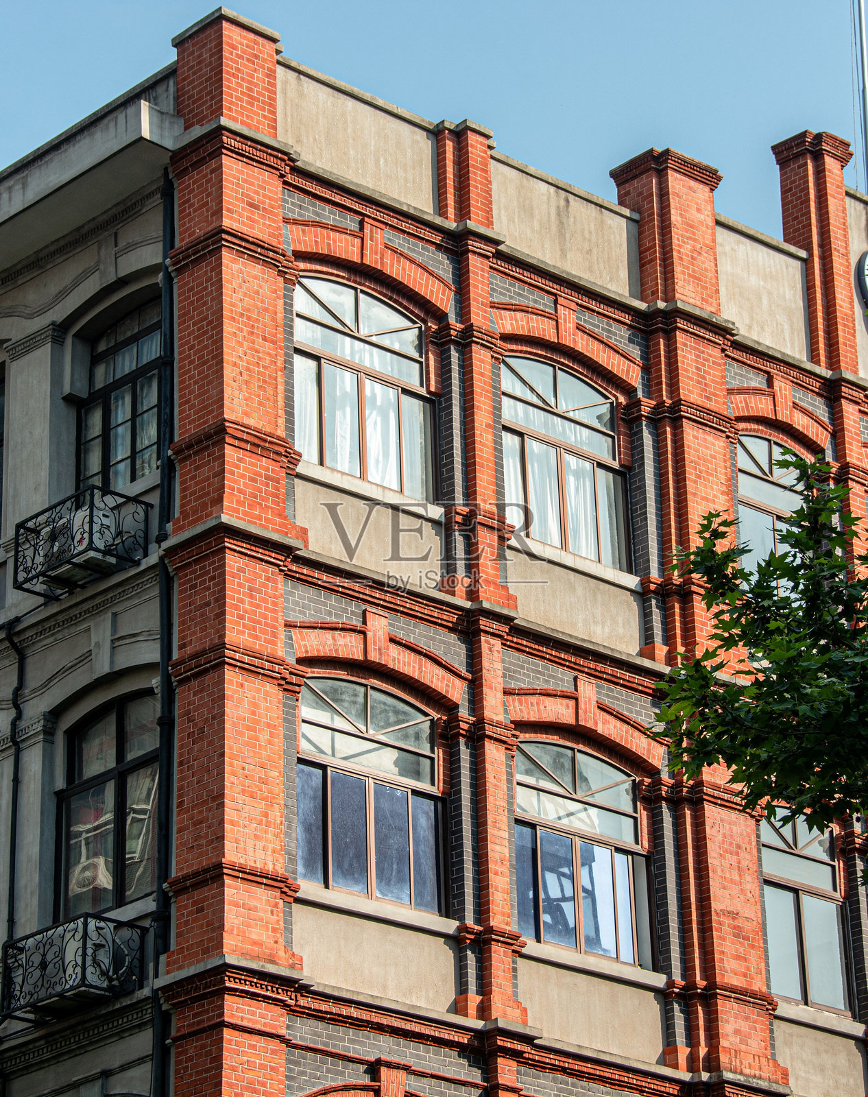历史砖砌建筑立面，配有大窗户和阳台。照片摄影图片