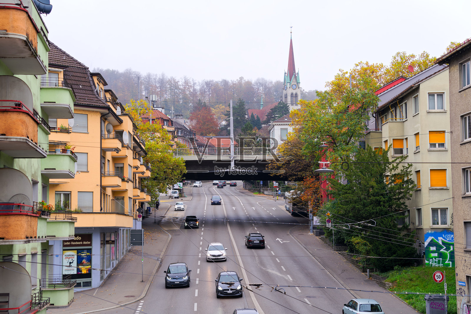 在瑞士苏黎世的一个雾蒙蒙的秋日，俯瞰玫瑰花园街，背景中有交通和教堂塔楼。照片摄影图片