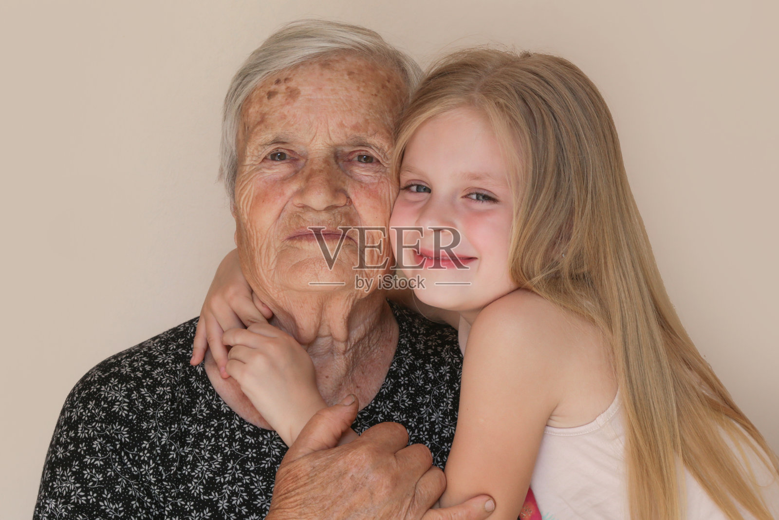 幸福的家庭，孩子和曾祖母拥抱，放松，微笑，彼此相爱和亲密，在家中快乐而满足地展现爱与关怀。照片摄影图片