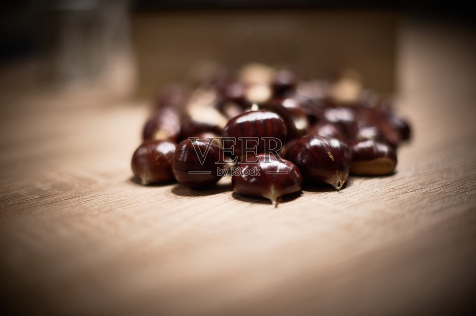 新鲜采摘的秋季栗子，摆放在木头上，静物画照片摄影图片