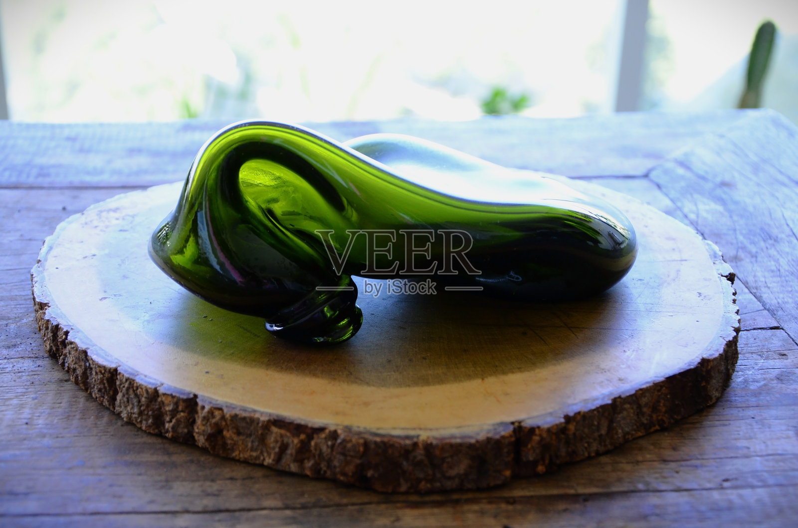 一只绿色的装饰瓶在桌子下融化了照片摄影图片