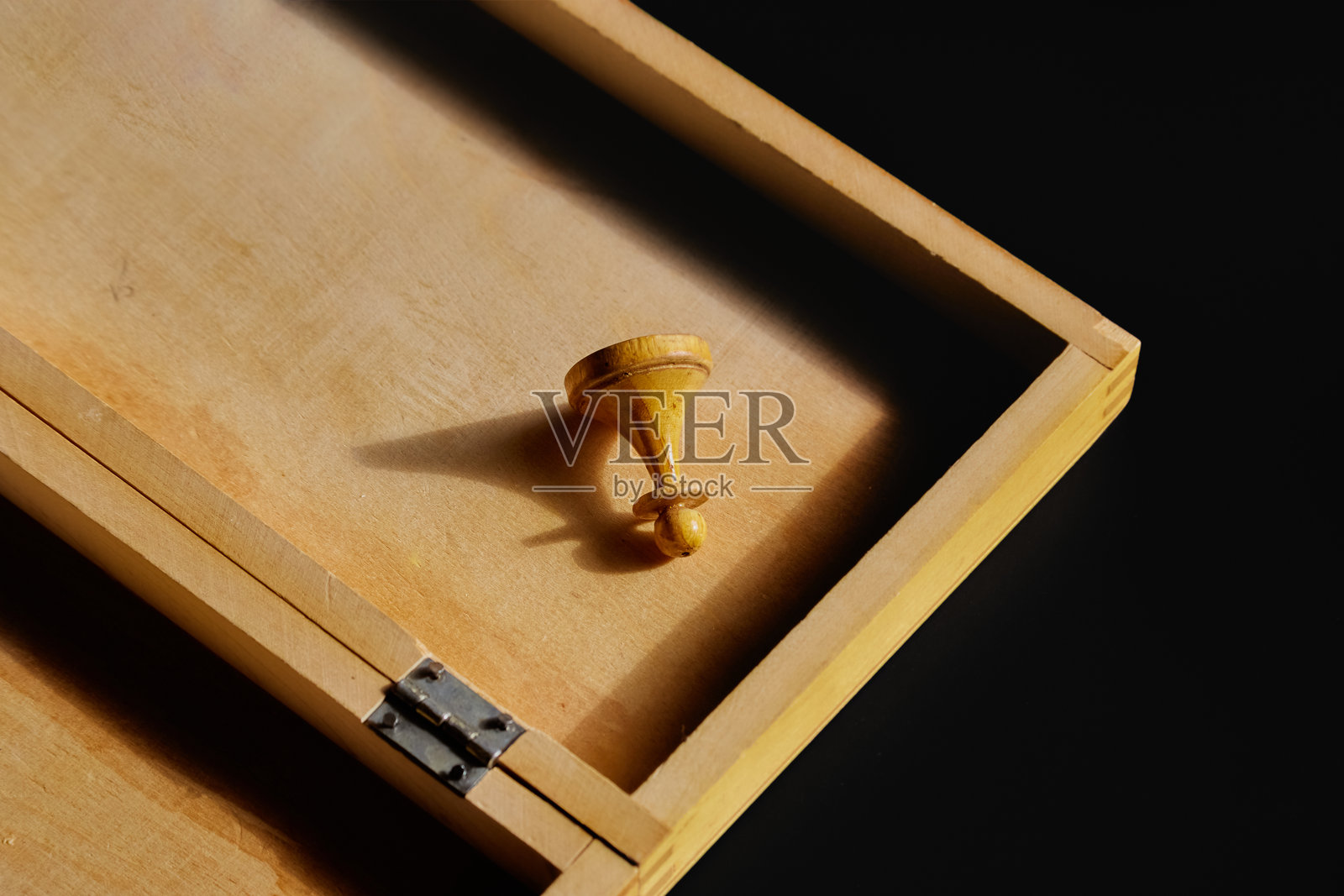 一个旧木制棋子放在黑色背景的木盒中。照片摄影图片