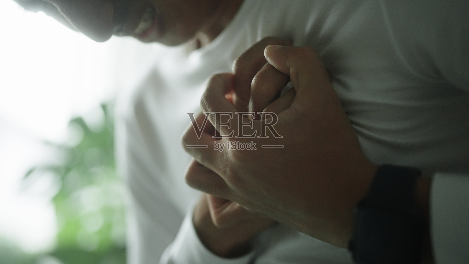 胸部疼痛的男子。照片摄影图片