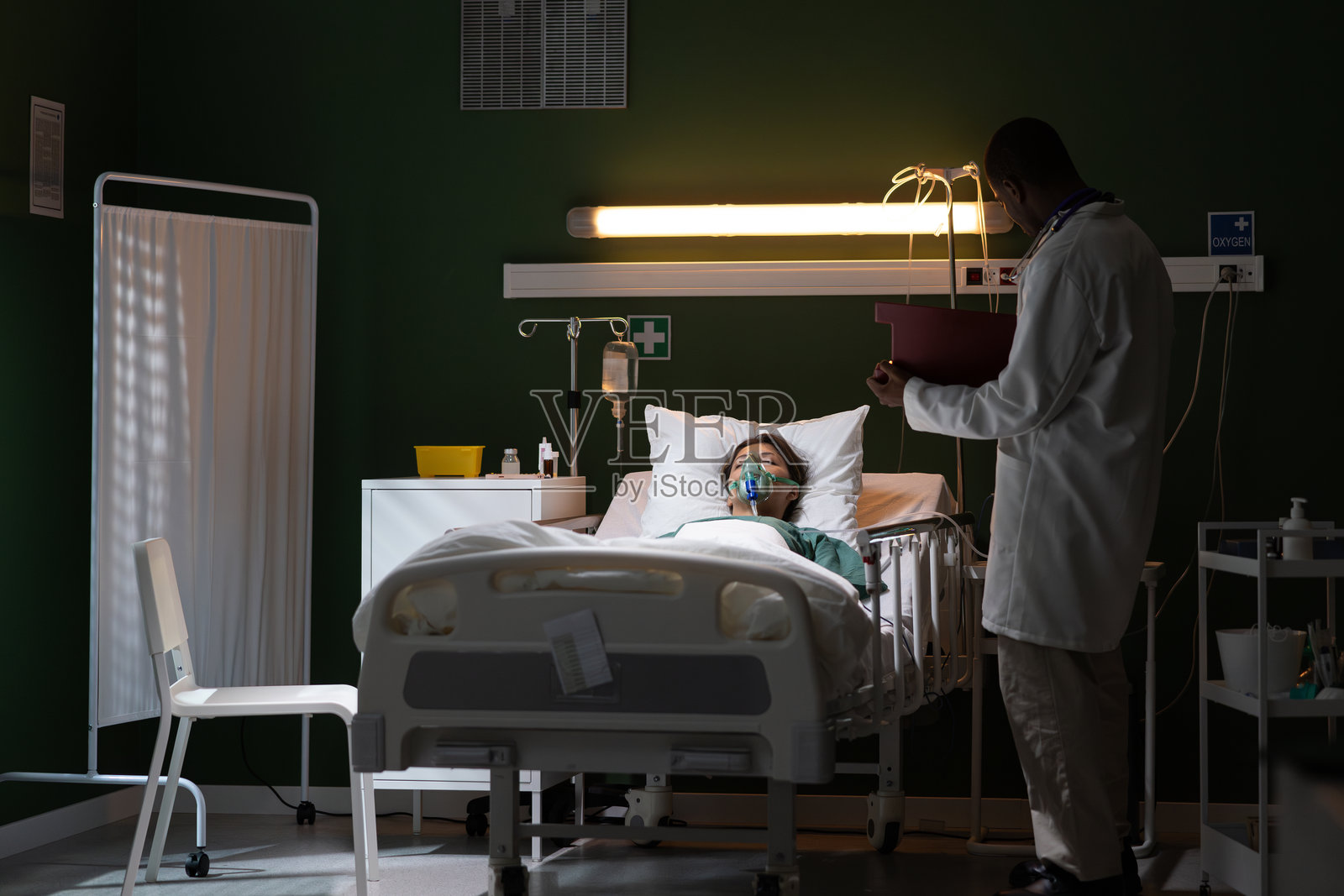 医生在医院无意识女孩的床边记录信息照片摄影图片