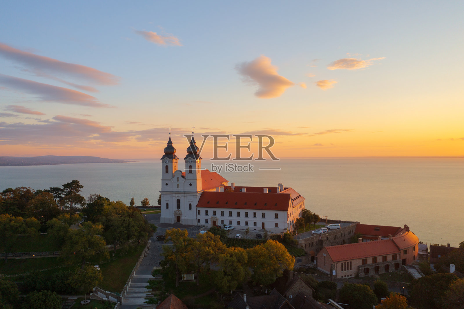 匈牙利提哈尼 - 提哈尼著名本笃会修道院(提哈尼修道院)的空中天际线视图,日出时分美丽多彩的天空和云朵。照片摄影图片