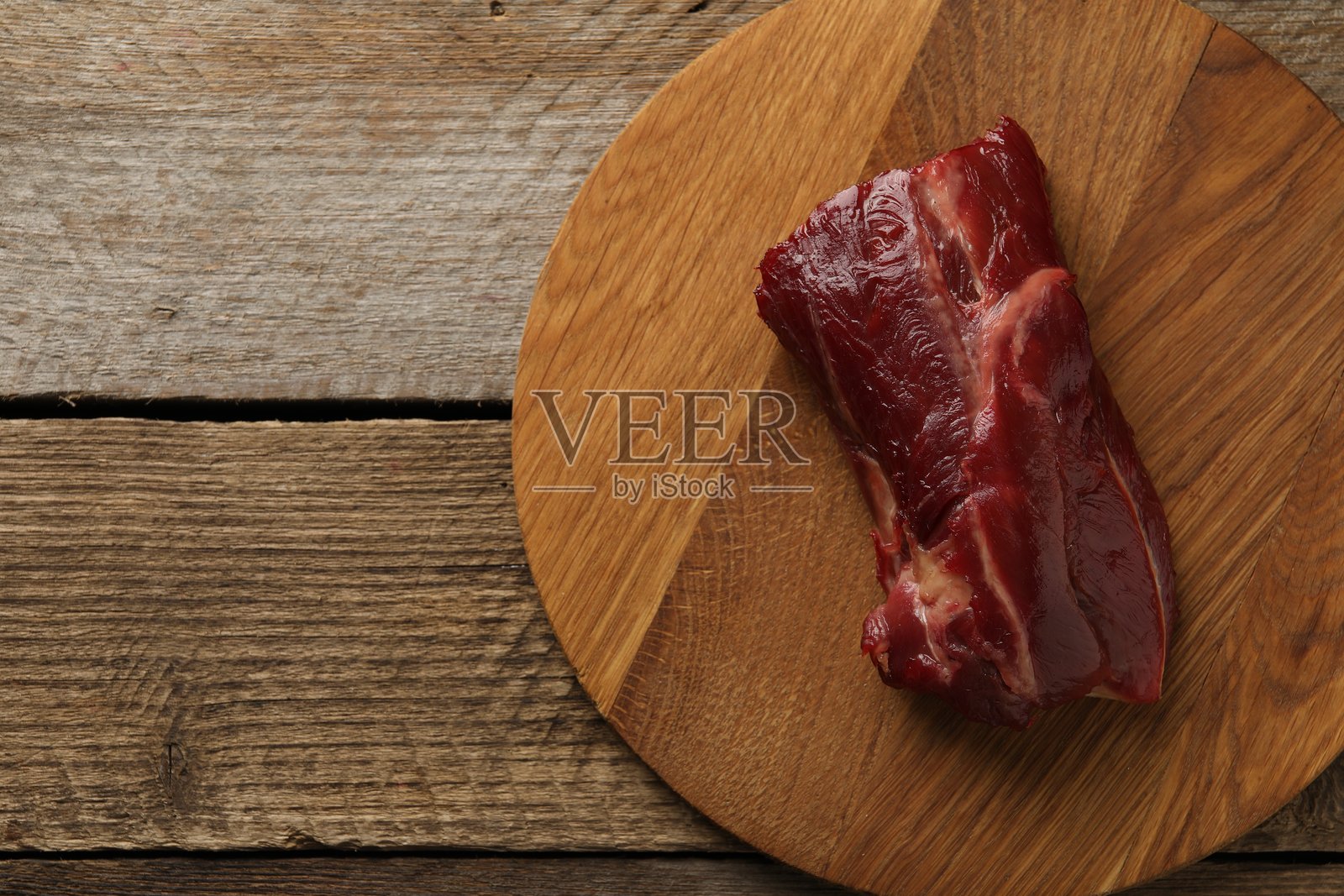 一块生牛肉放在木桌上，俯视图。留有文字空间。照片摄影图片