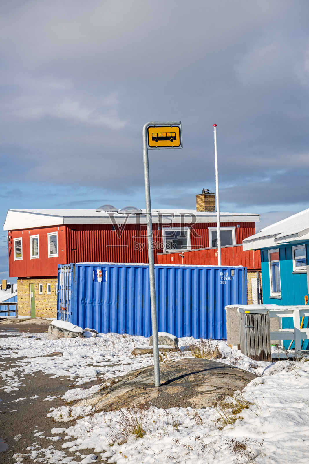 阳光明媚的日子里,雪中的公交车站照片摄影图片