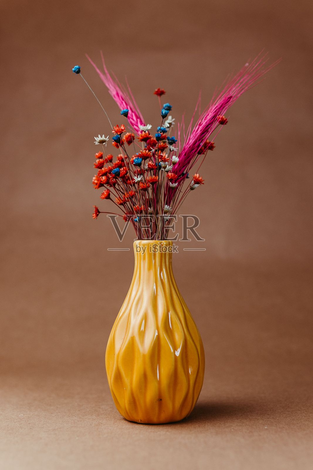 五颜六色的干花在黄色花瓶中照片摄影图片