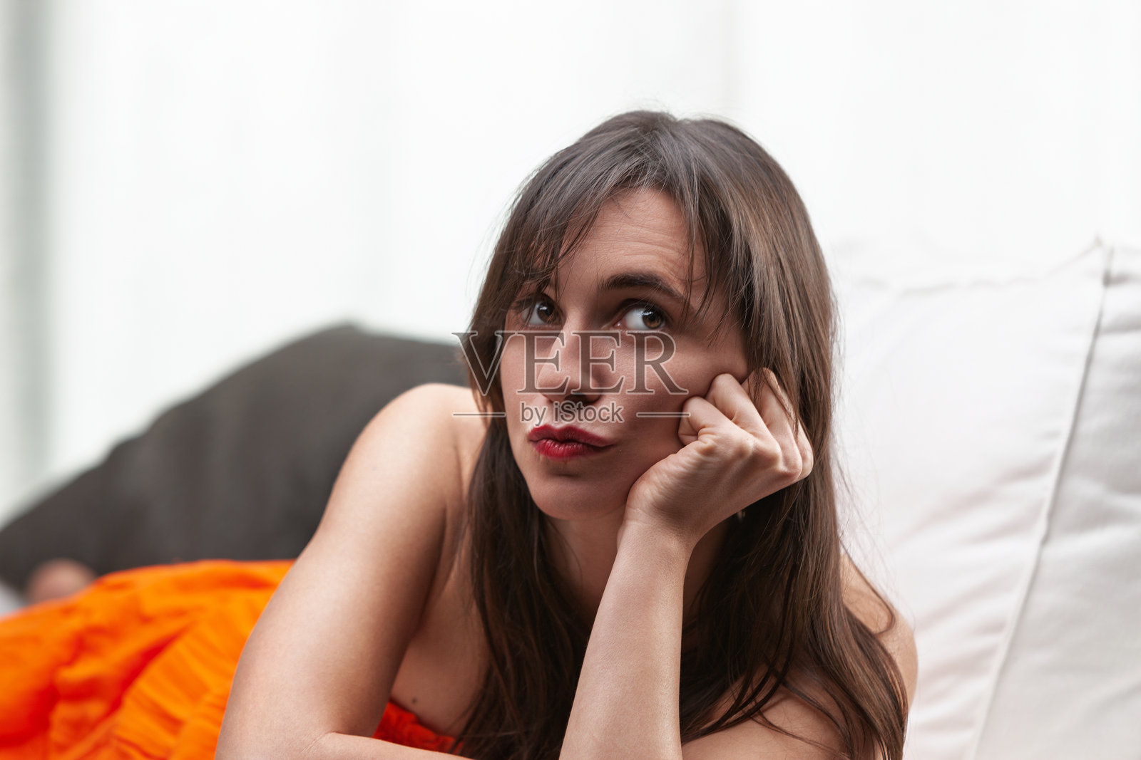 无聊的女人躺在沙发上做搞笑的表情照片摄影图片