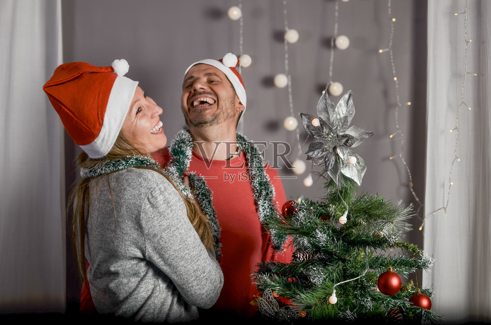 情侣在装饰圣诞树照片摄影图片