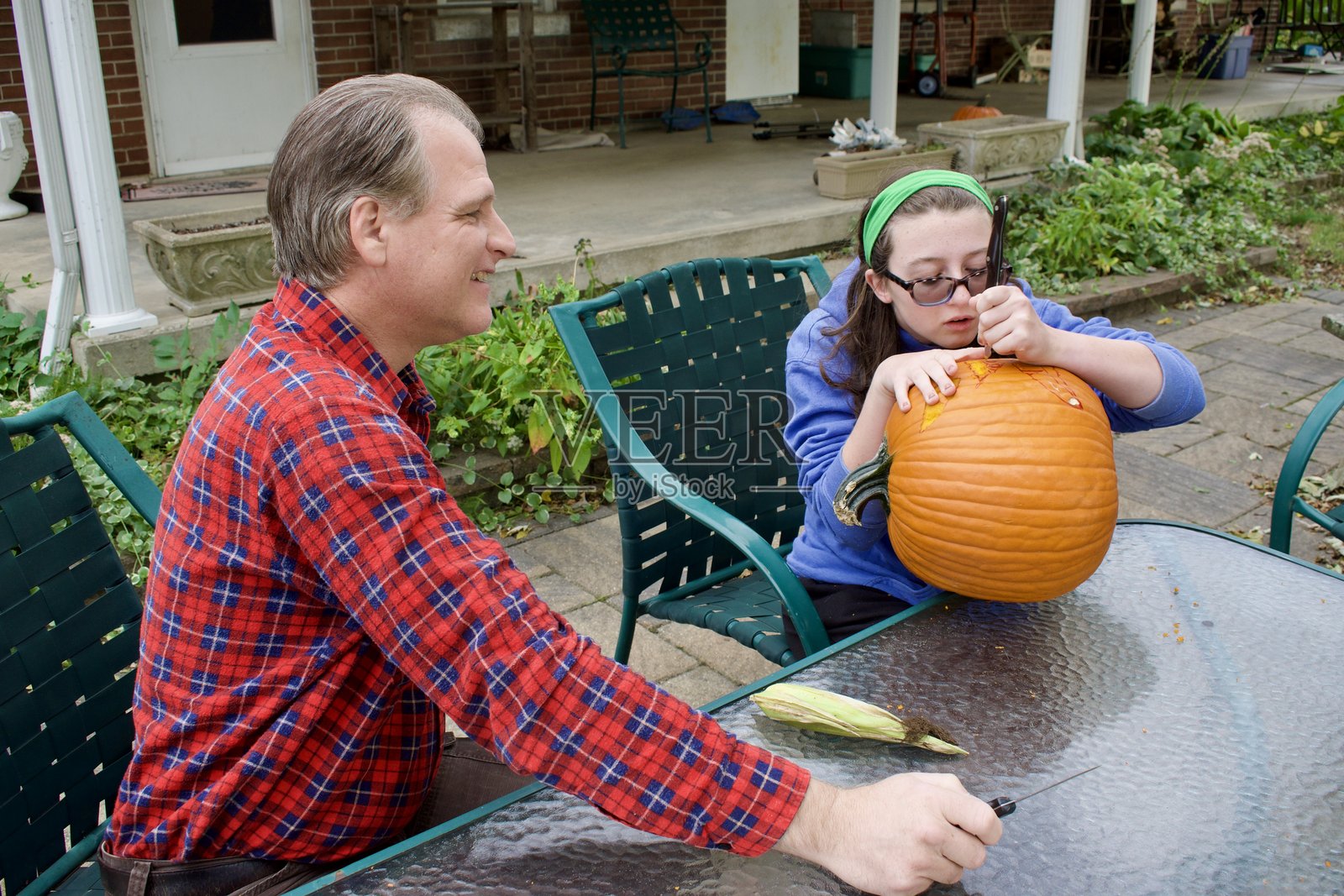 男人和少女在雕刻南瓜照片摄影图片