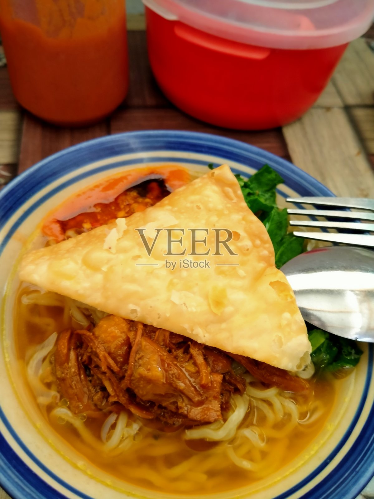 桌子上放着一碗非常美味的鸡肉面。照片摄影图片