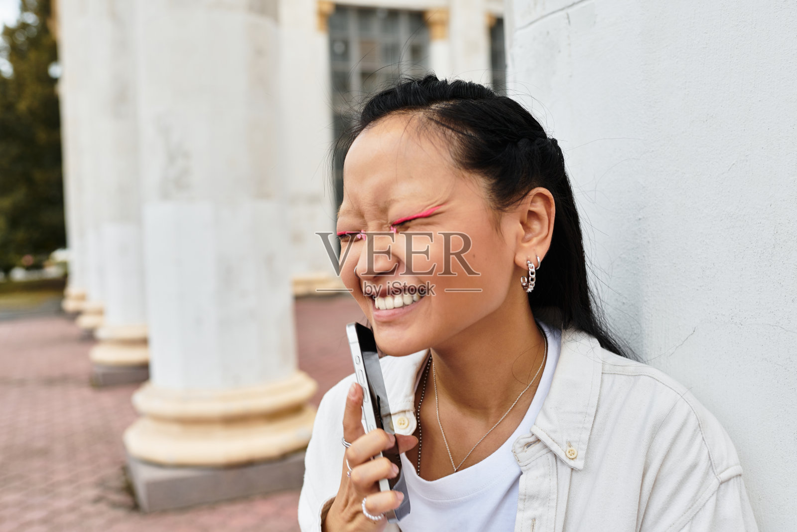 一位快乐的年轻亚洲学生在阳光明媚的下午时尚地享受校园生活照片摄影图片