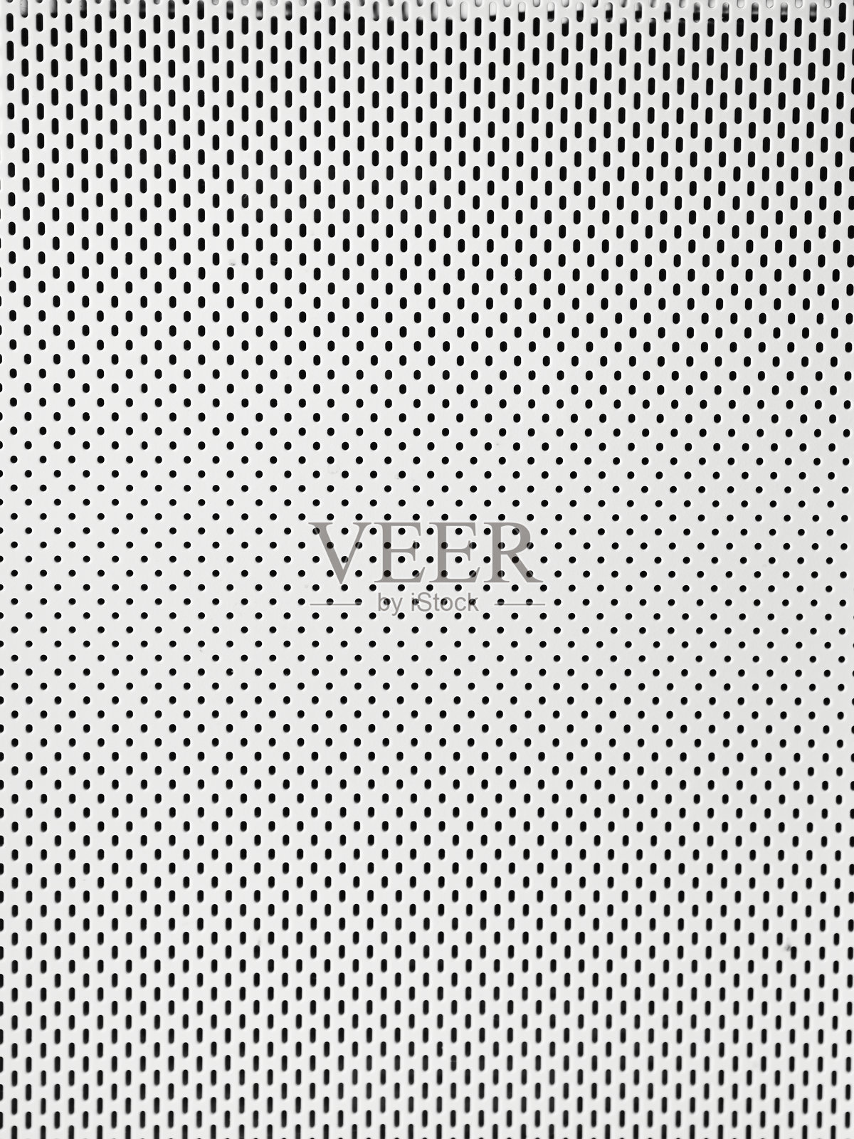 白色金属板上有许多小圆孔。照片摄影图片