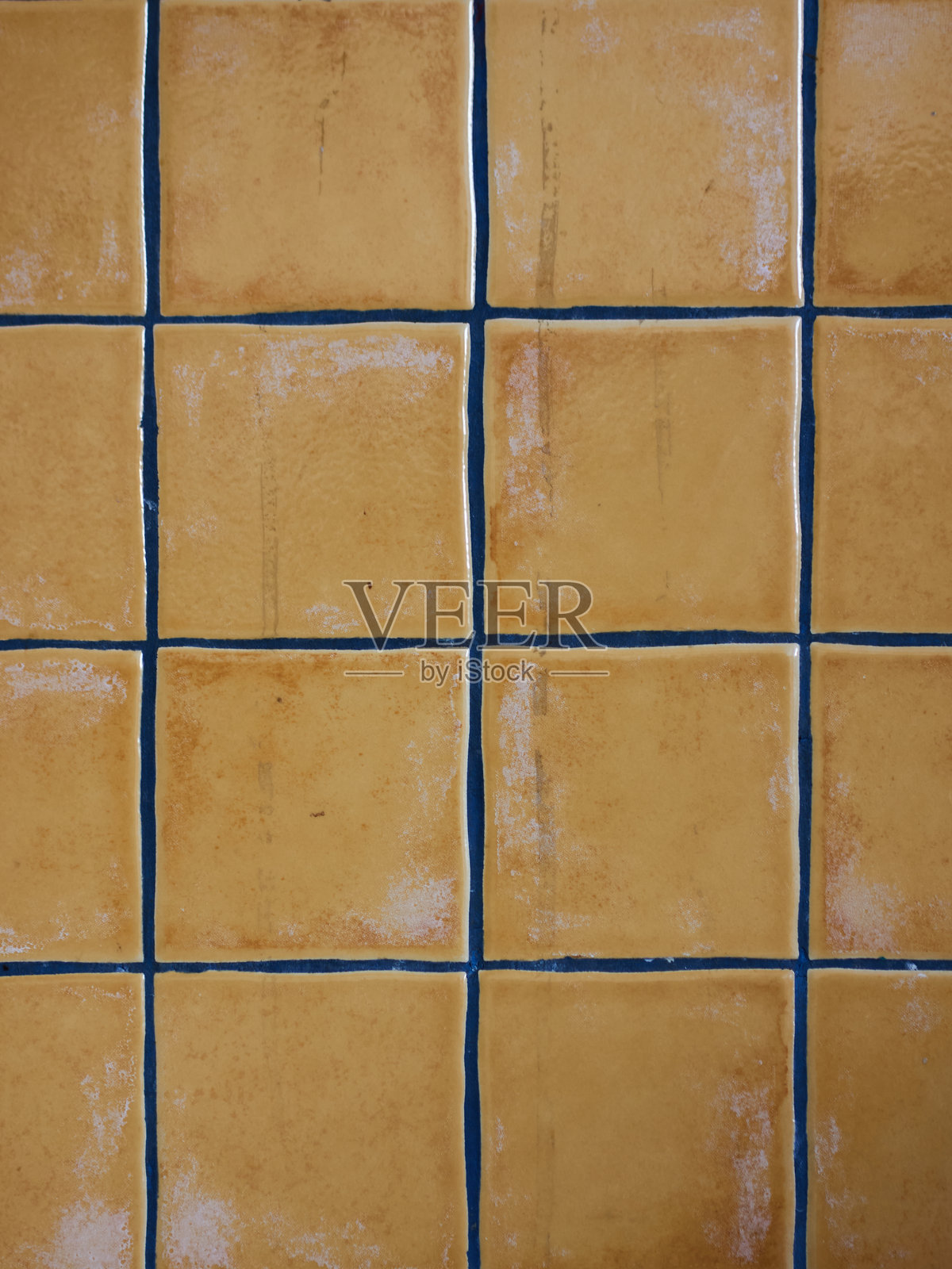 明亮的黄色方形瓷砖以网格图案排列，白色的填缝线形成鲜明对比。照片摄影图片