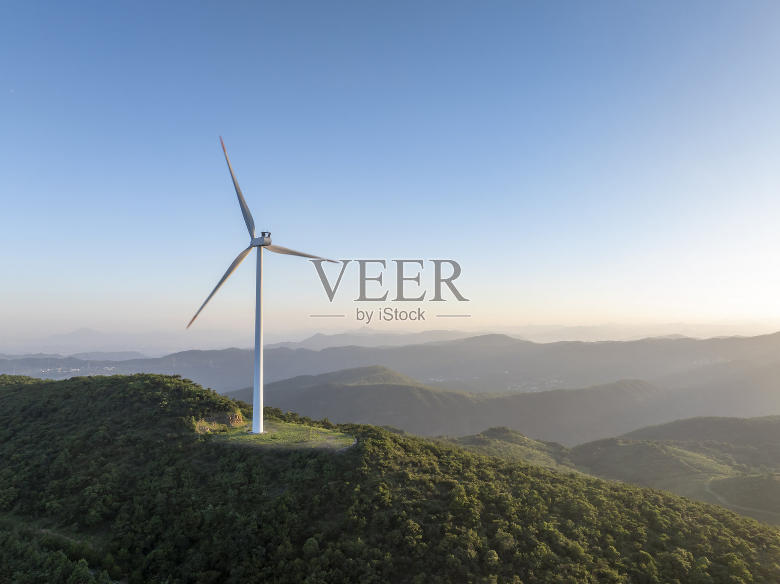 森林山顶上的风力涡轮机照片摄影图片