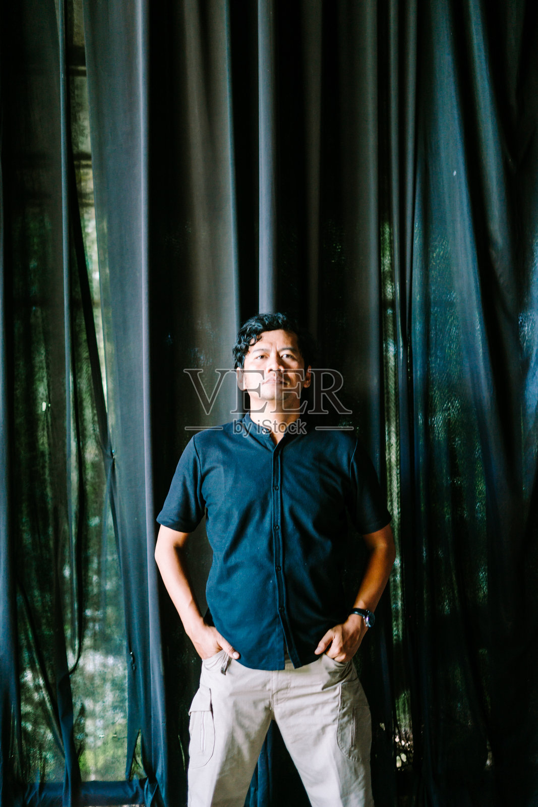 一位东南亚男子在户外随意地把手插进口袋里照片摄影图片