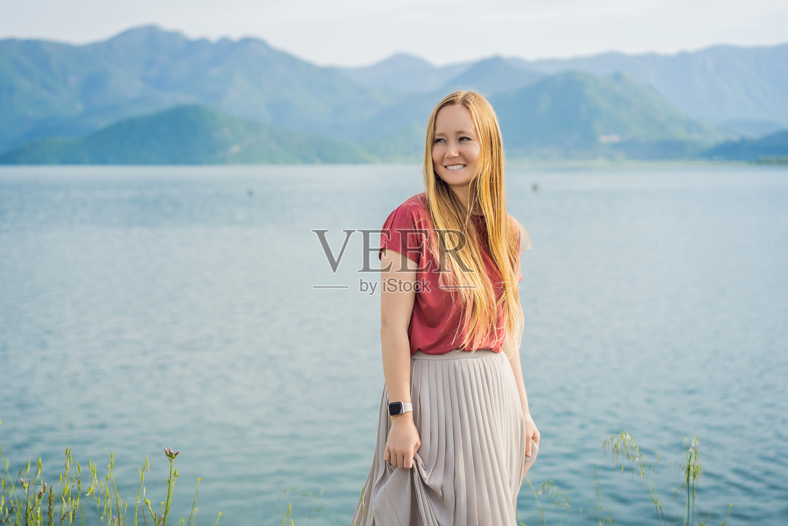 在斯卡达尔湖国家公园背景下的女游客。黑山。斯卡达尔湖。黎明。俯瞰视角。巴尔干地区最大的湖泊。迪纳里克高地的山脉。斯卡达尔湖的沼泽岸边和多彩植被。照片摄影图片