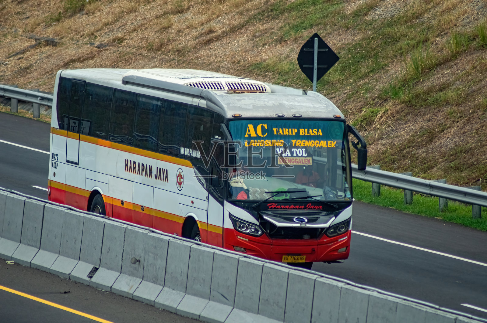 一辆哈拉潘贾亚的城际巴士在高速公路上行驶，展示了印度尼西亚现代公共交通。非常适合关于交通基础设施和旅行的文章。印度尼西亚，2024年10月31日照片摄影图片