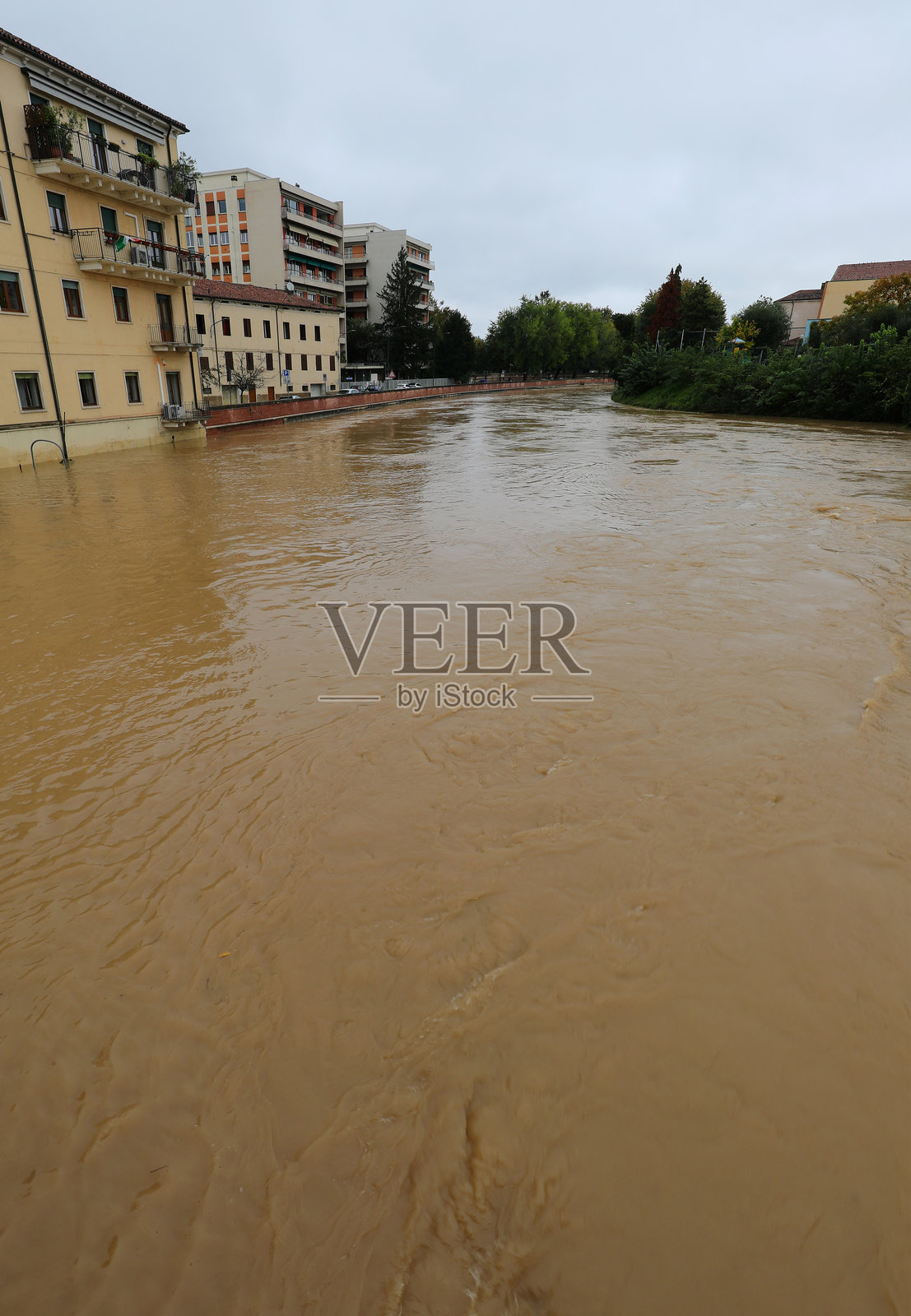 意大利的巴基利奥内河因暴雨而面临洪水风险，房屋几乎被淹没。照片摄影图片