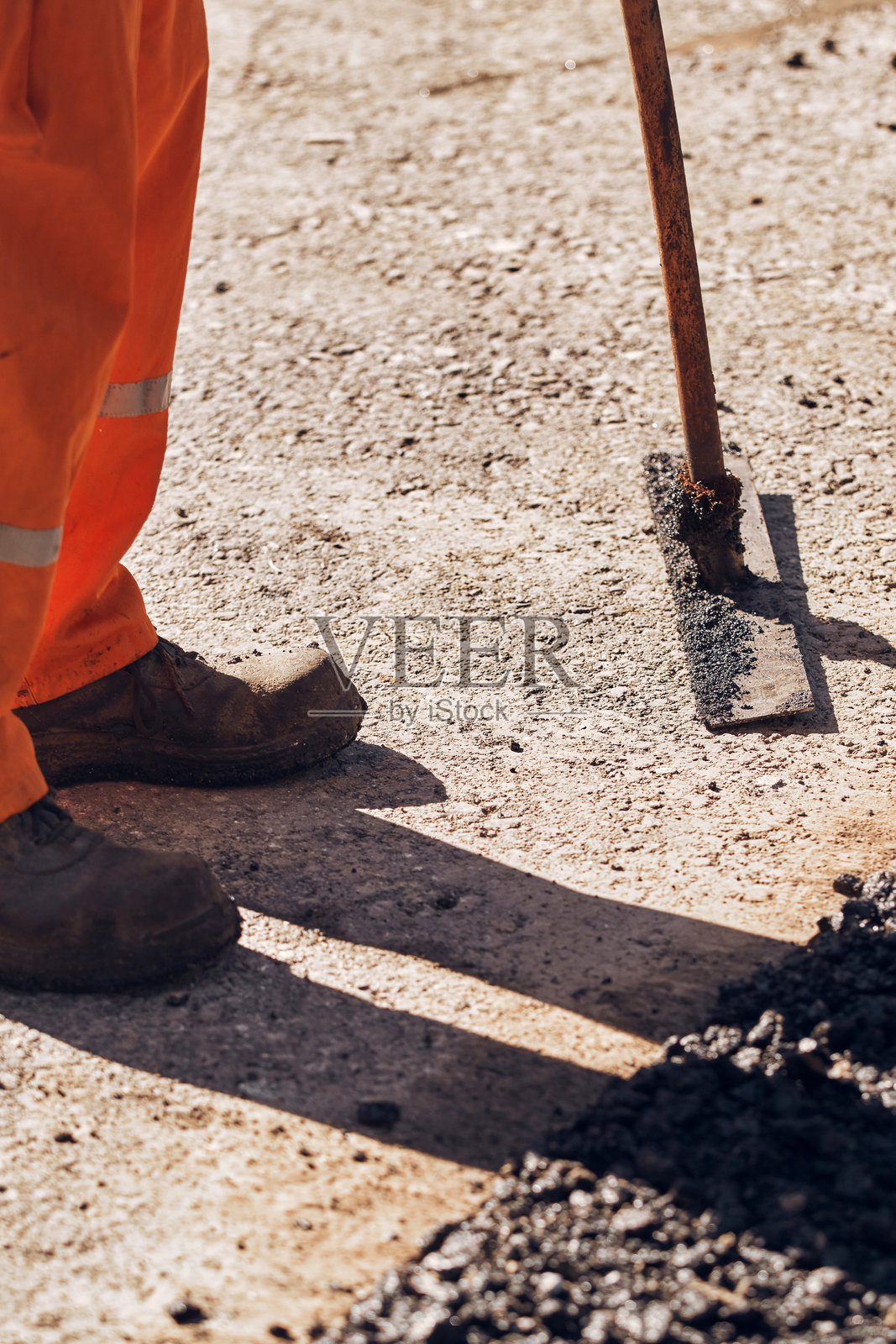 建筑工人在公共街道上铺设新的沥青层。照片摄影图片