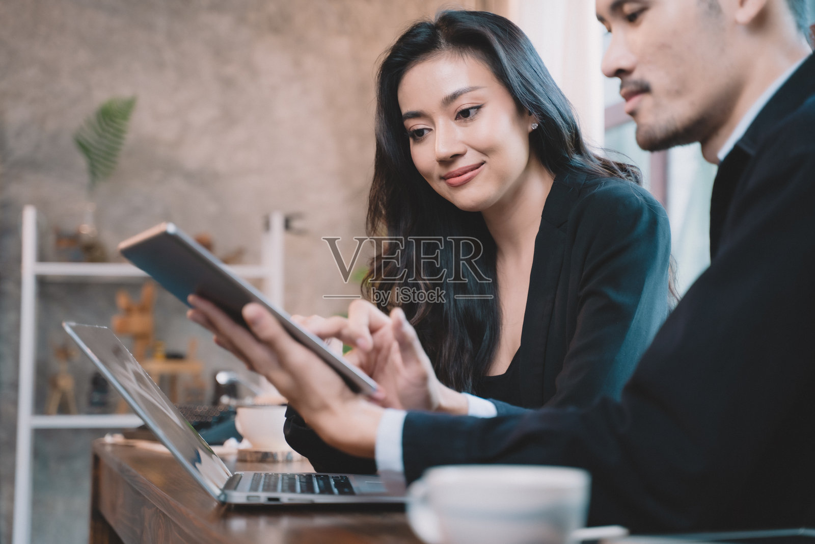 两位商务人士在项目会议中愉快交流。两位合作伙伴正在讨论商业计划与技术。照片摄影图片