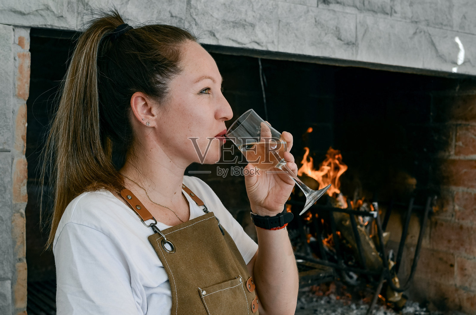 微笑的女性正在喝一杯白葡萄酒照片摄影图片