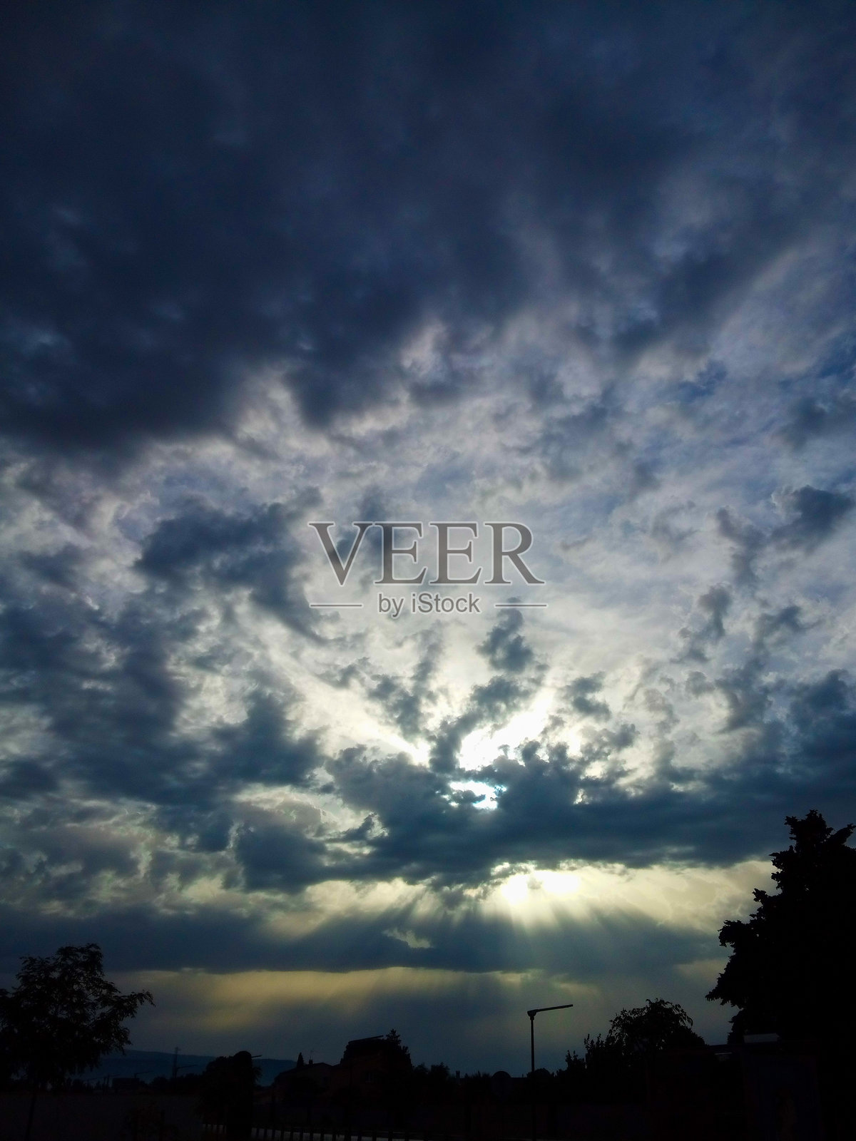 阳光穿透普罗旺斯天空中的灰色云层照片摄影图片