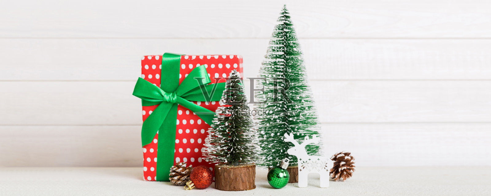 圣诞节布置。手工礼品盒、小树、树枝和手工DIY装饰品在白色背景上。新年概念。圣诞家居装饰平铺，俯视图，留白空间。照片摄影图片