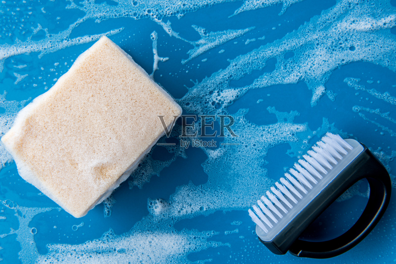 蓝色陶瓷桌子上的洗碗海绵，留有空白空间。照片摄影图片