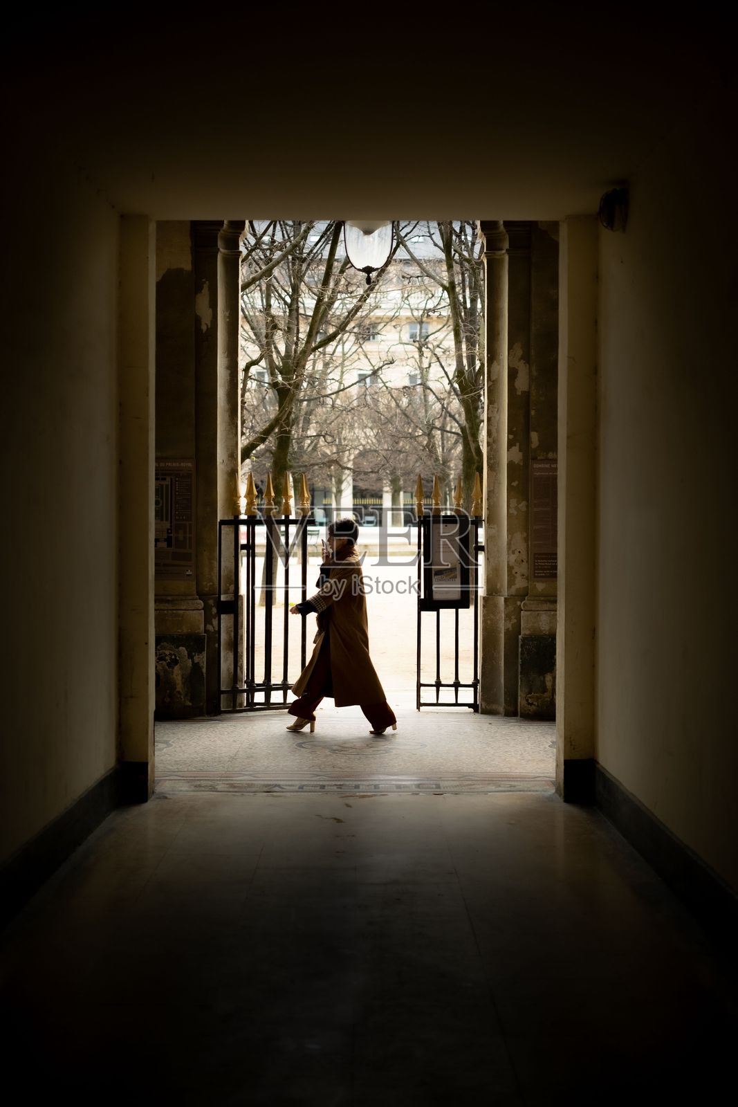 一位穿着风衣的女性在法国巴黎的街头悠闲地散步照片摄影图片