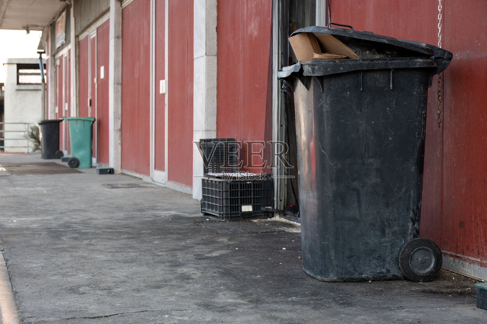 工业巷道中的黑色垃圾桶和箱子照片摄影图片