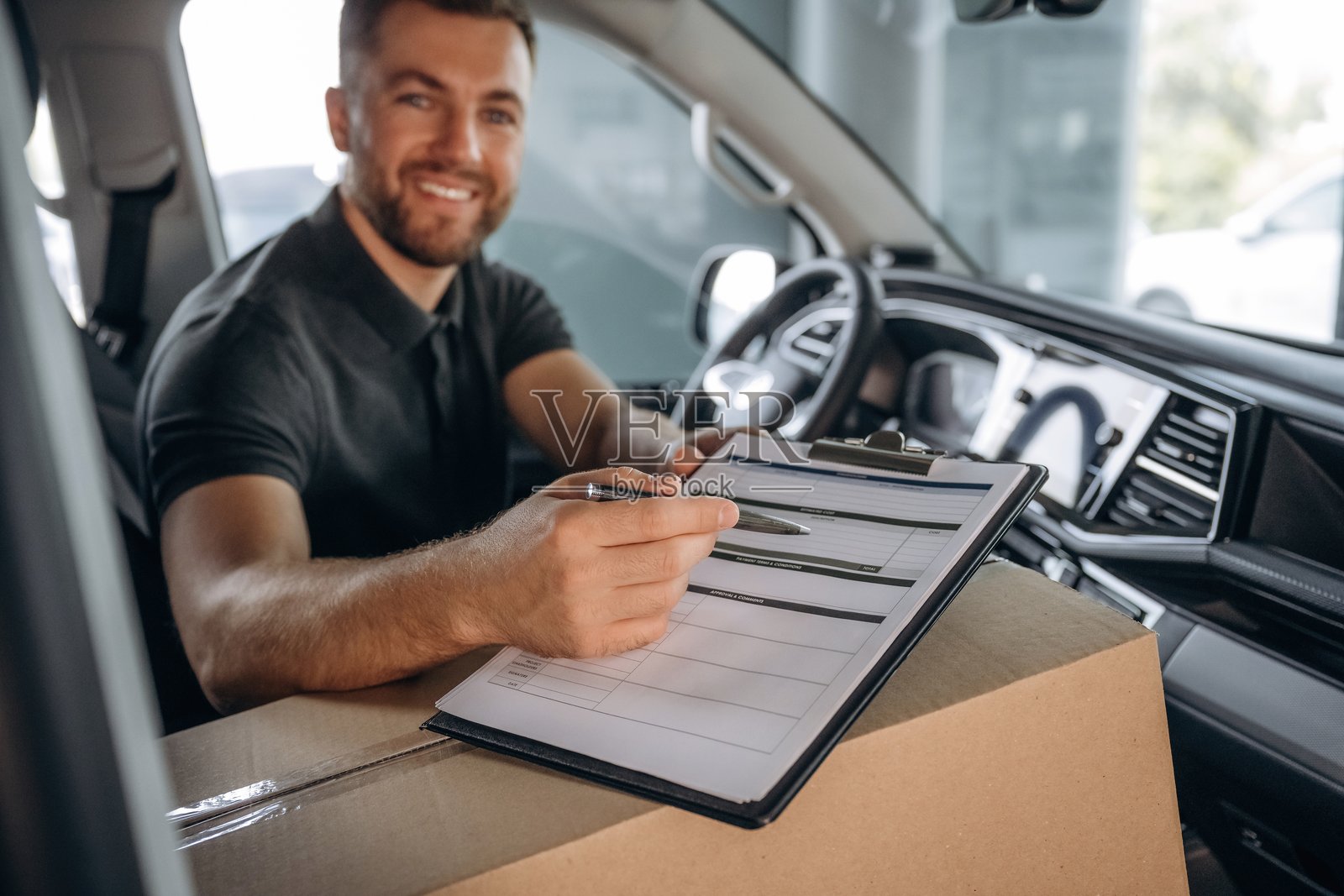 送货员或装卸工在车里与箱子一起照片摄影图片