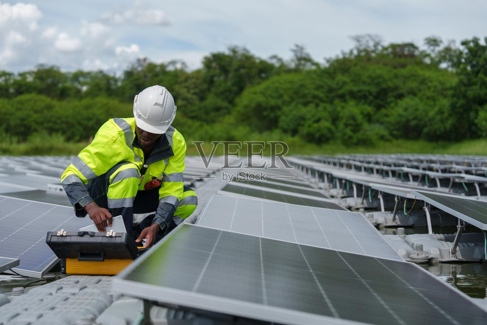 非裔美国工程师仔细检查先进的浮动太阳能电池板系统，该系统旨在为复杂行业利用可再生能源。照片摄影图片