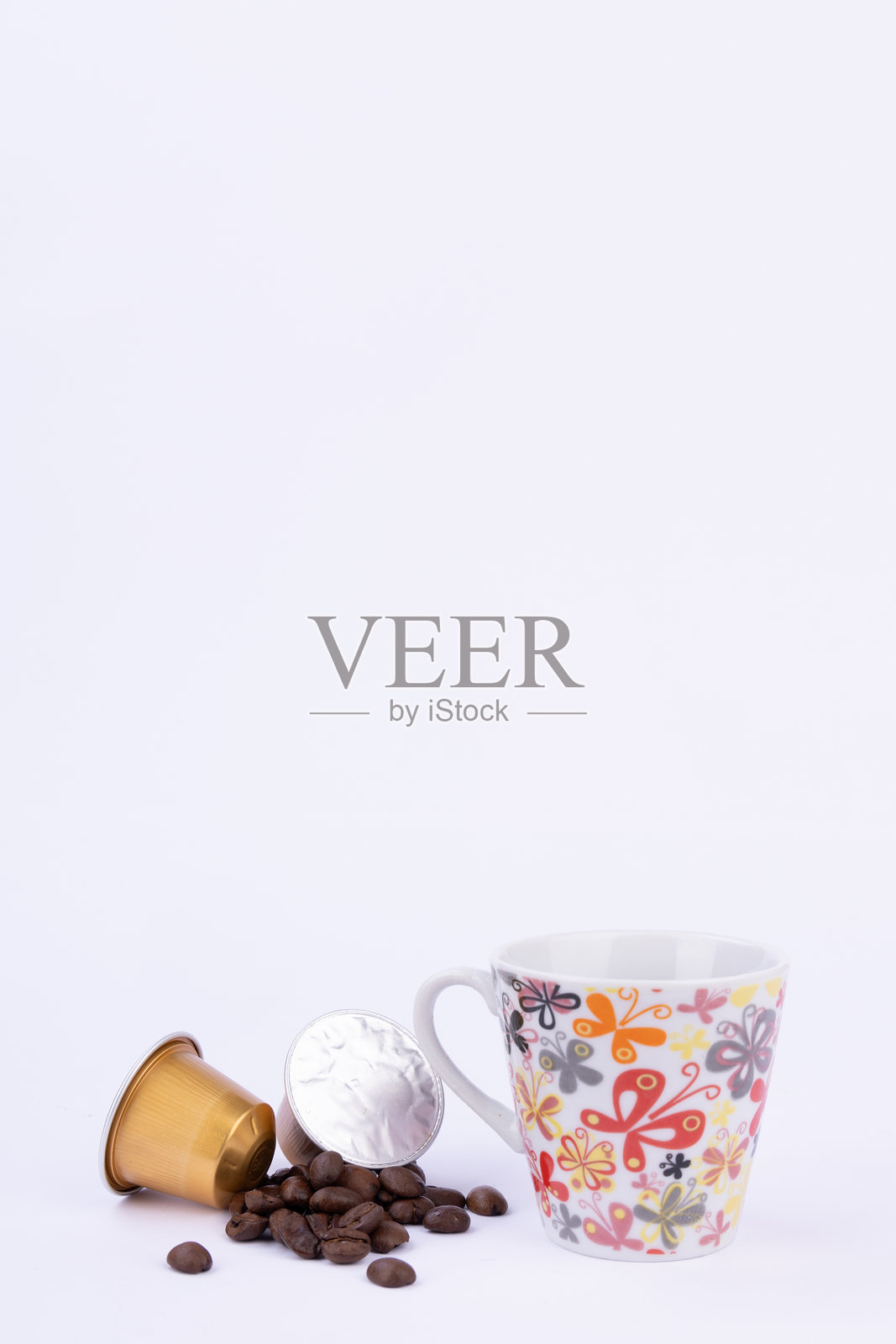 奢华的金色胶囊与咖啡豆和一杯咖啡相伴照片摄影图片