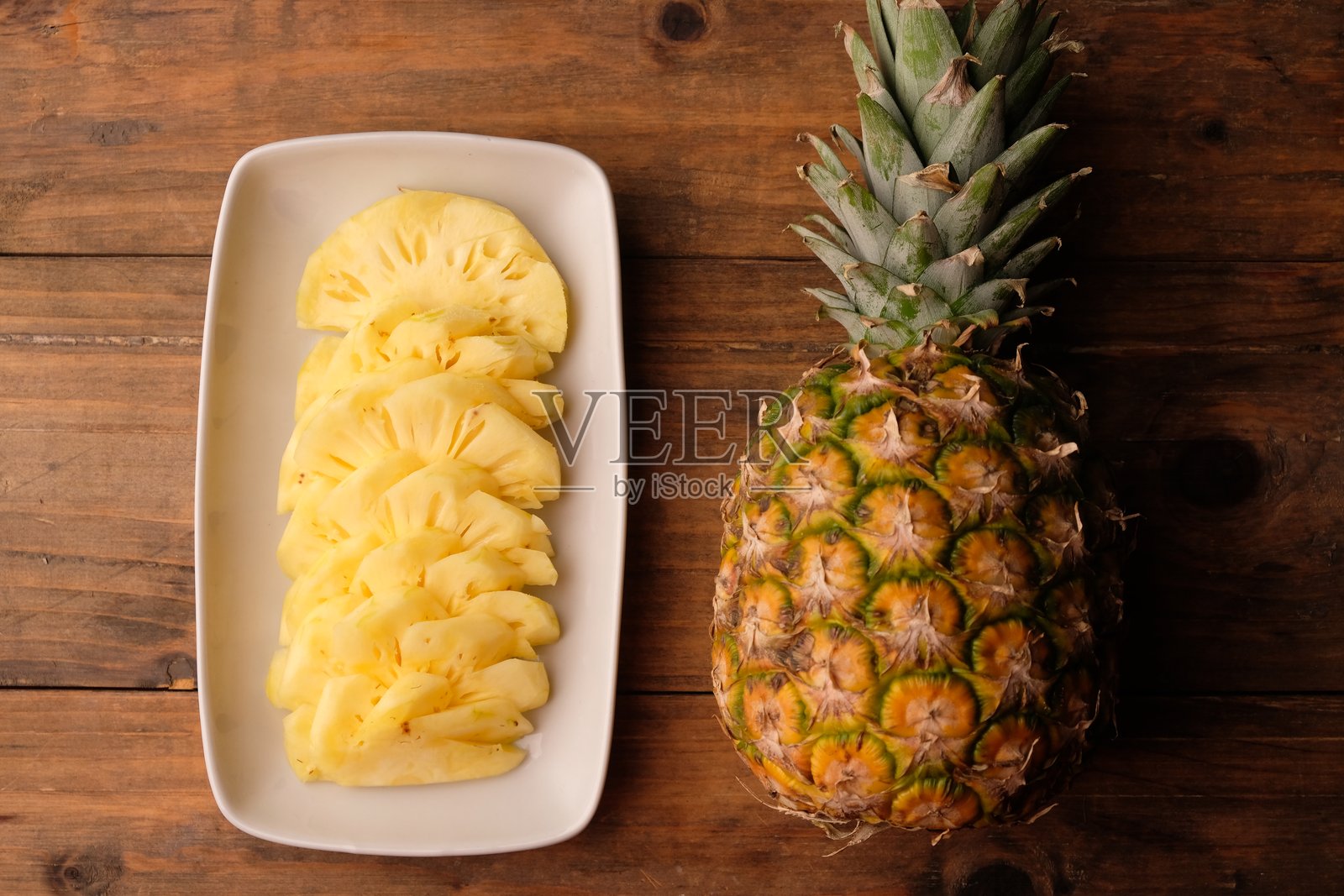 白色陶瓷盘上的菠萝片。凤梨。热带水果。照片摄影图片