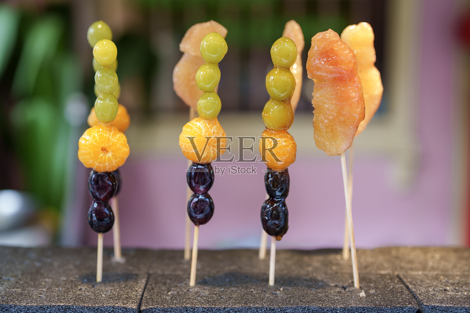 糖葫芦是一种在马六甲街市非常受欢迎的街头小吃，通常是将水果裹上糖浆后串在棍子上。照片摄影图片