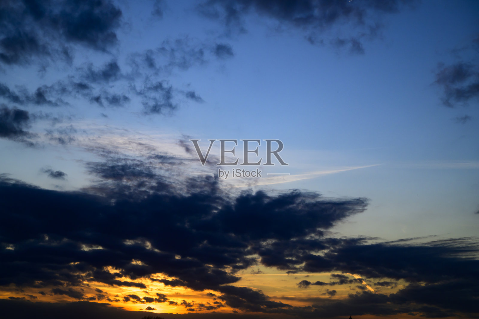 日落时分蓝天中的蓬松云朵照片摄影图片