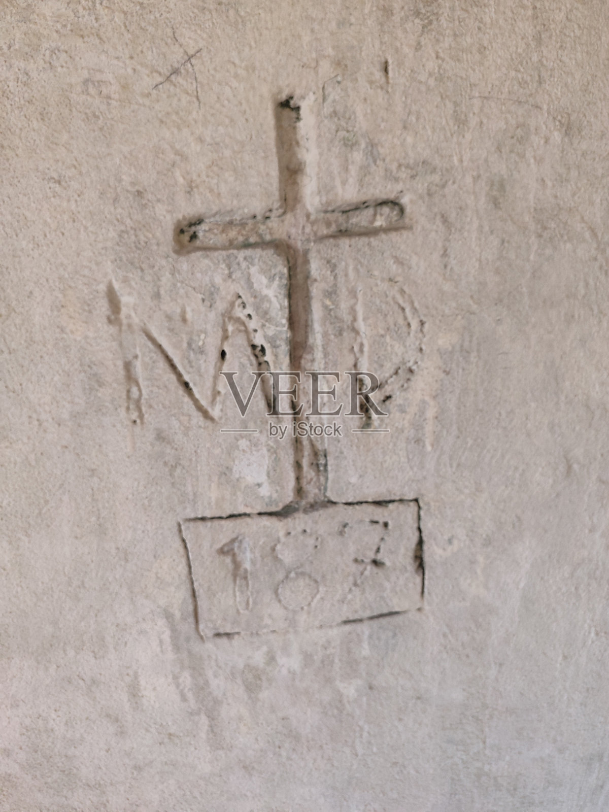 一幅历史十字架的雕刻，带有首字母和一个显著的过去日期照片摄影图片