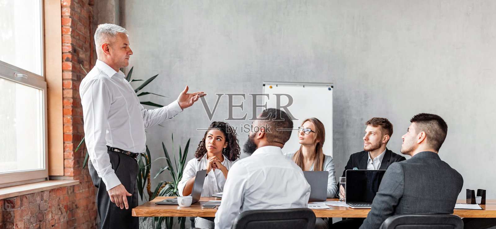 商人在现代办公室与员工会议中发表演讲照片摄影图片