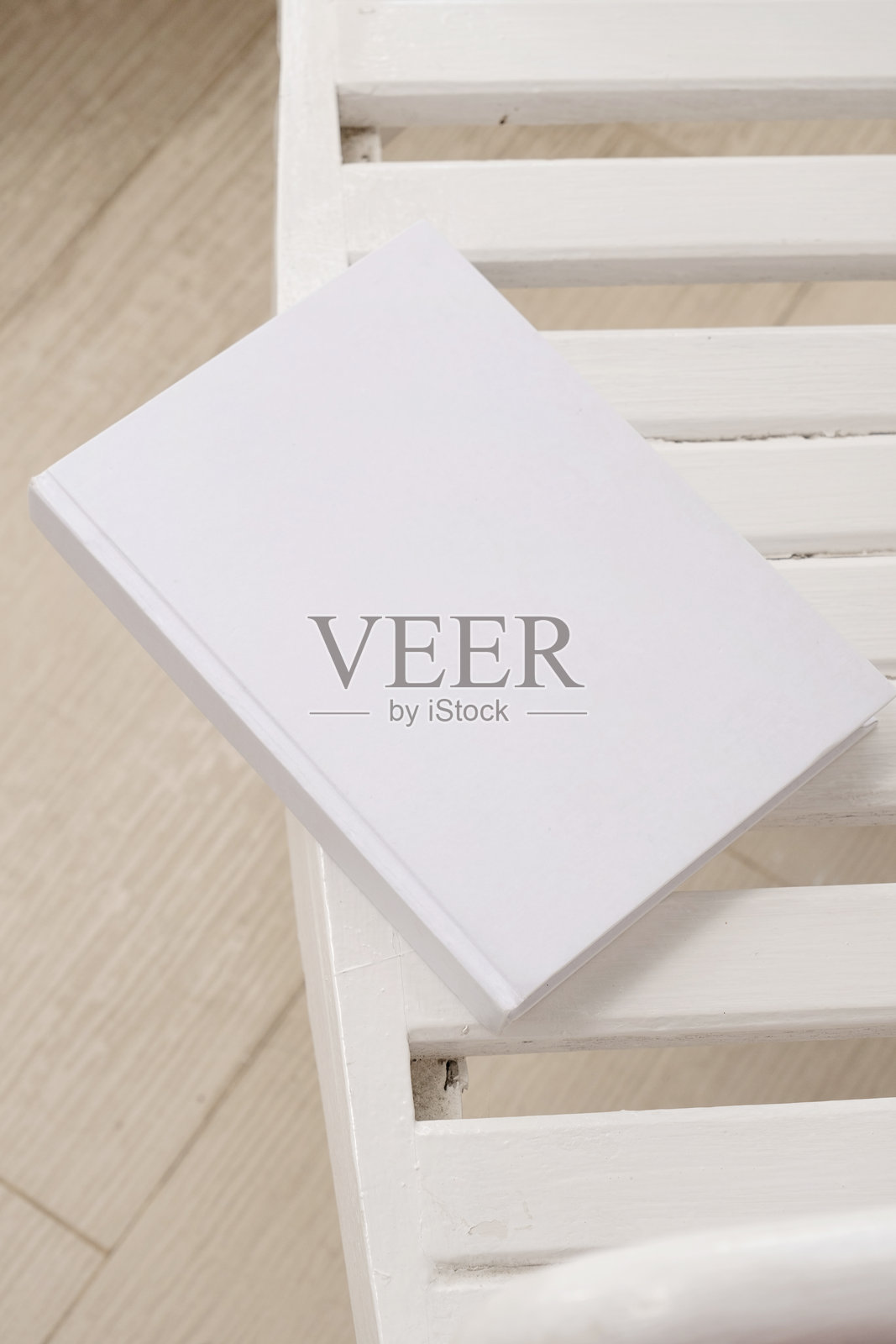 空白书籍封面模型放在户外木桌上，酒店阳台或露台上照片摄影图片