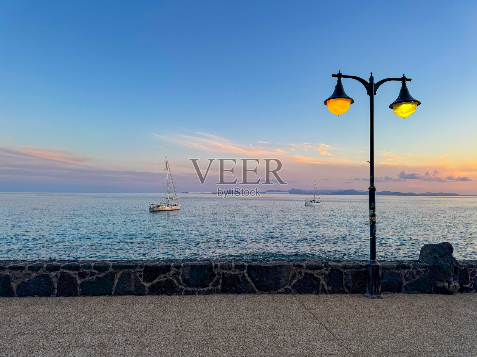 一盏路灯高高矗立在宁静的水面前照片摄影图片