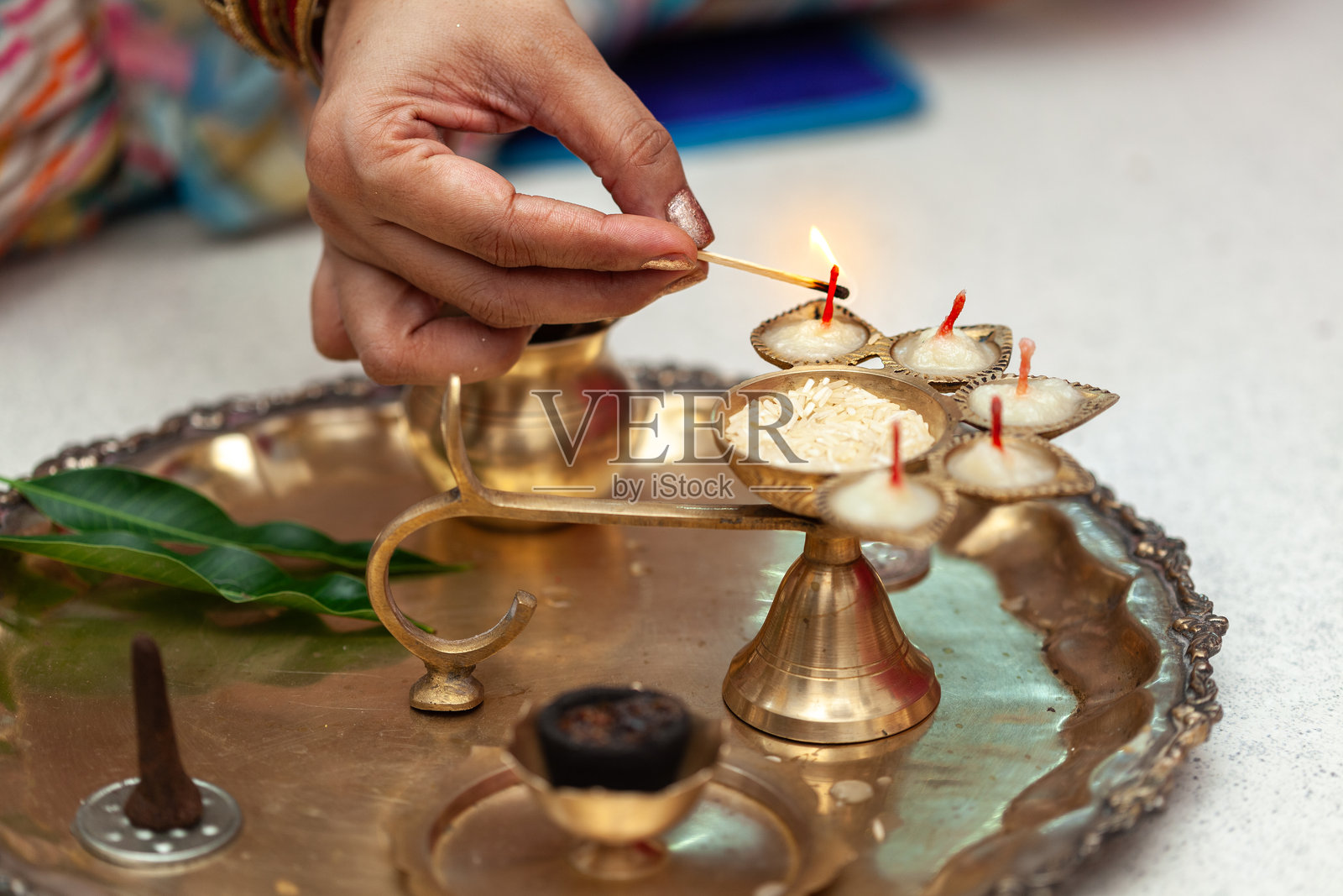 一位印度女性点燃黄铜油灯以崇拜印度教神明。照片摄影图片