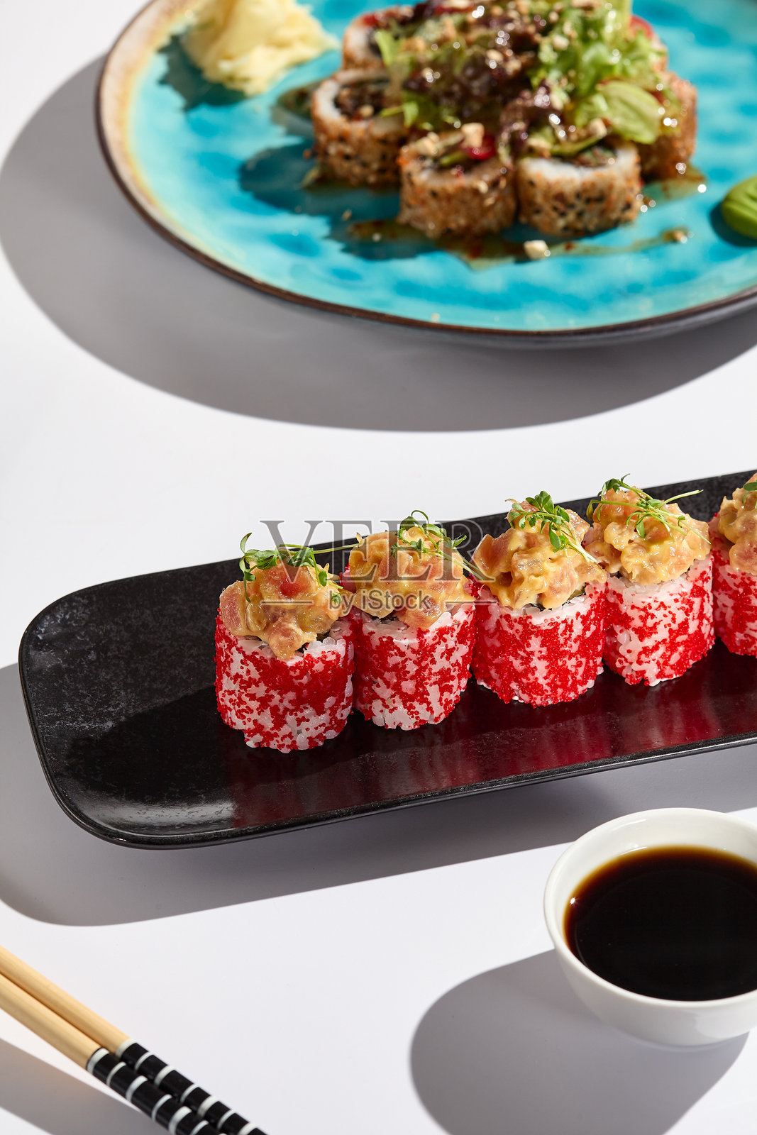 精致的三文鱼塔塔卷配飞鱼子酱，摆放在优雅的黑色盘子上 - 明亮清新的美食摄影照片摄影图片