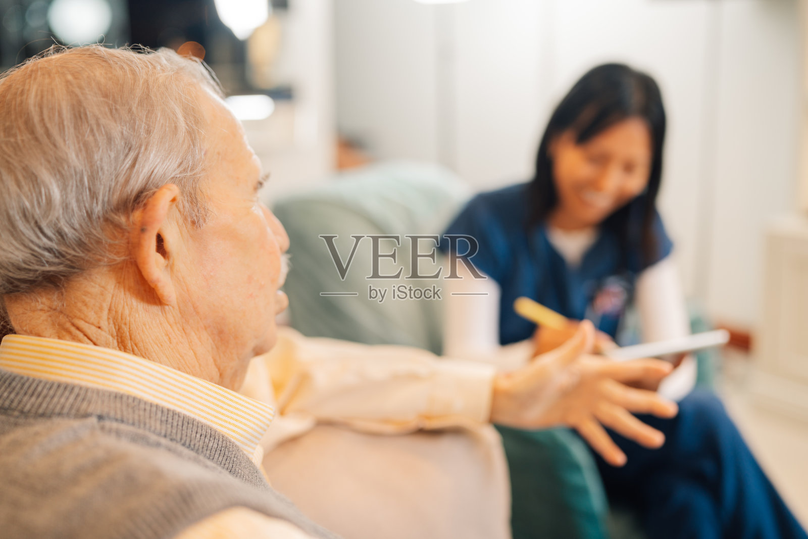 老人正在与来家访的护士交谈照片摄影图片