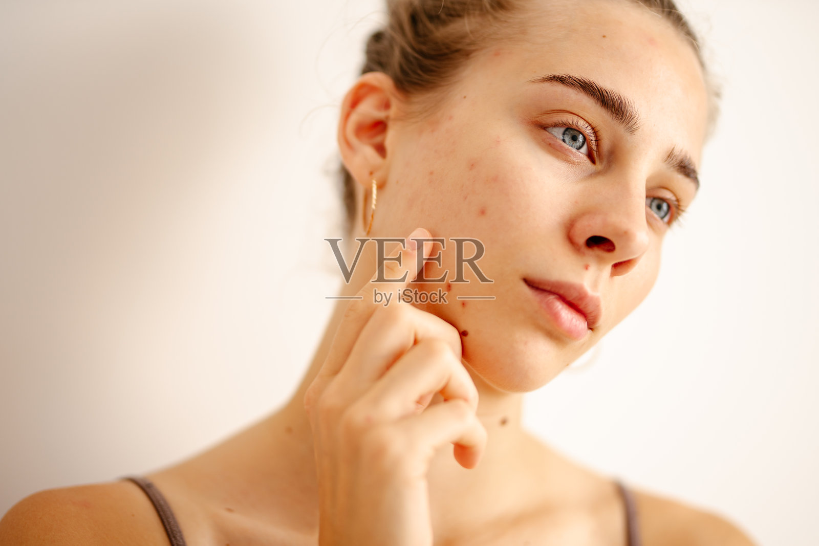 一位年轻女性在自然光下检查她的皮肤。照片摄影图片