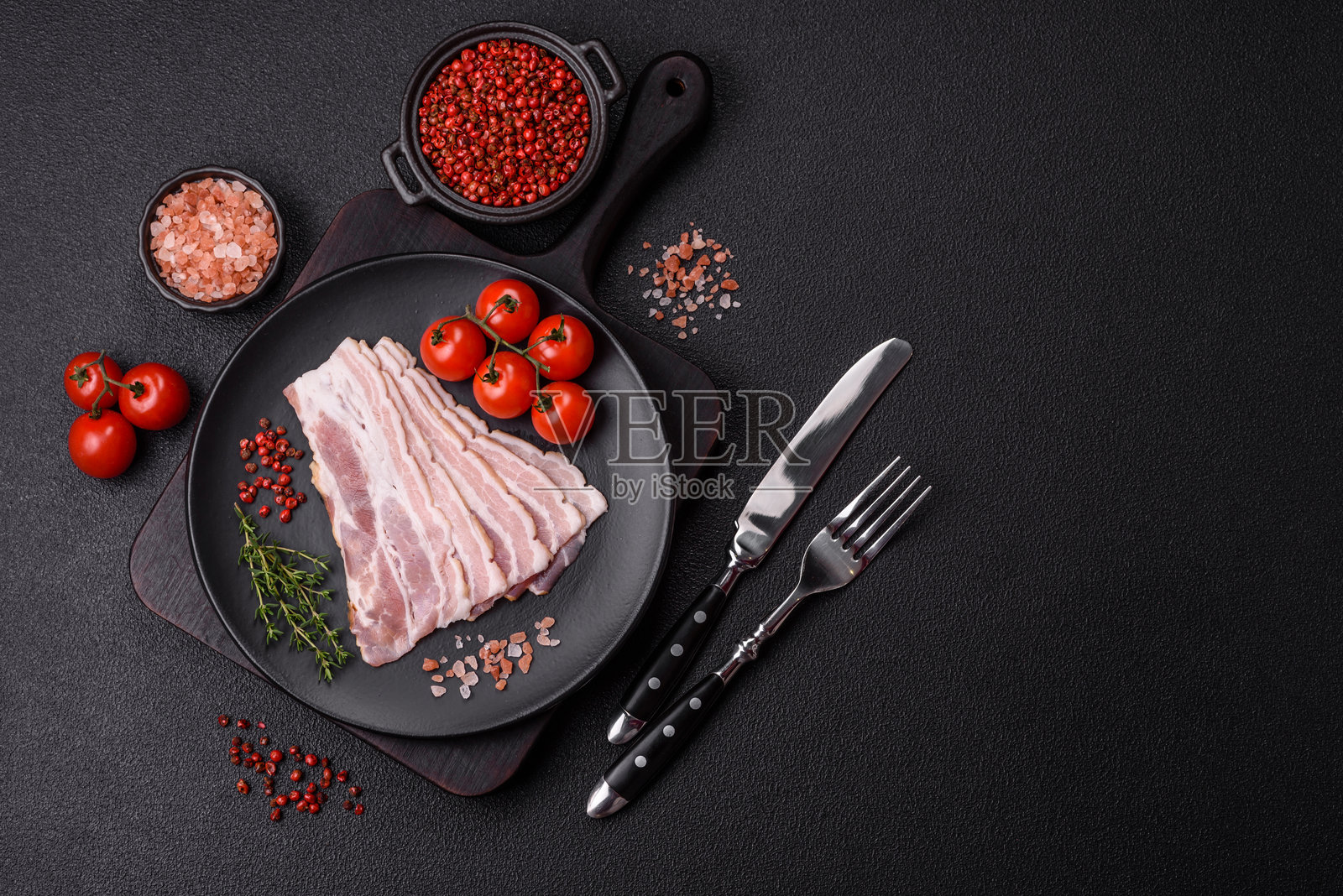 新鲜生培根切片，配以香料和草药照片摄影图片