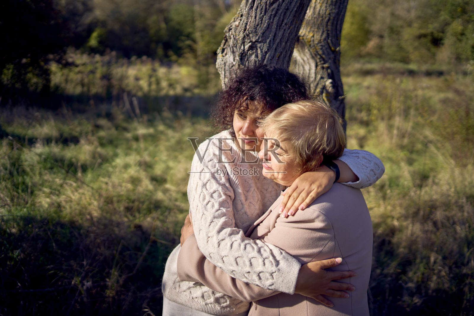 中年女儿和年迈母亲在秋季森林中散步照片摄影图片