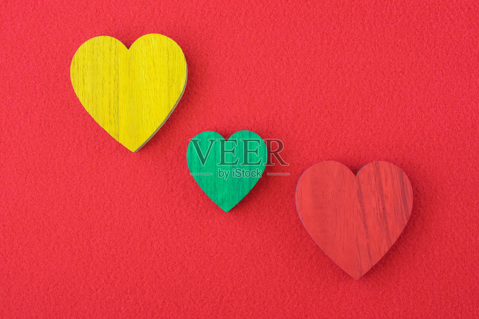 红色背景上的绿色、黄色和红色交通灯心形图案。照片摄影图片