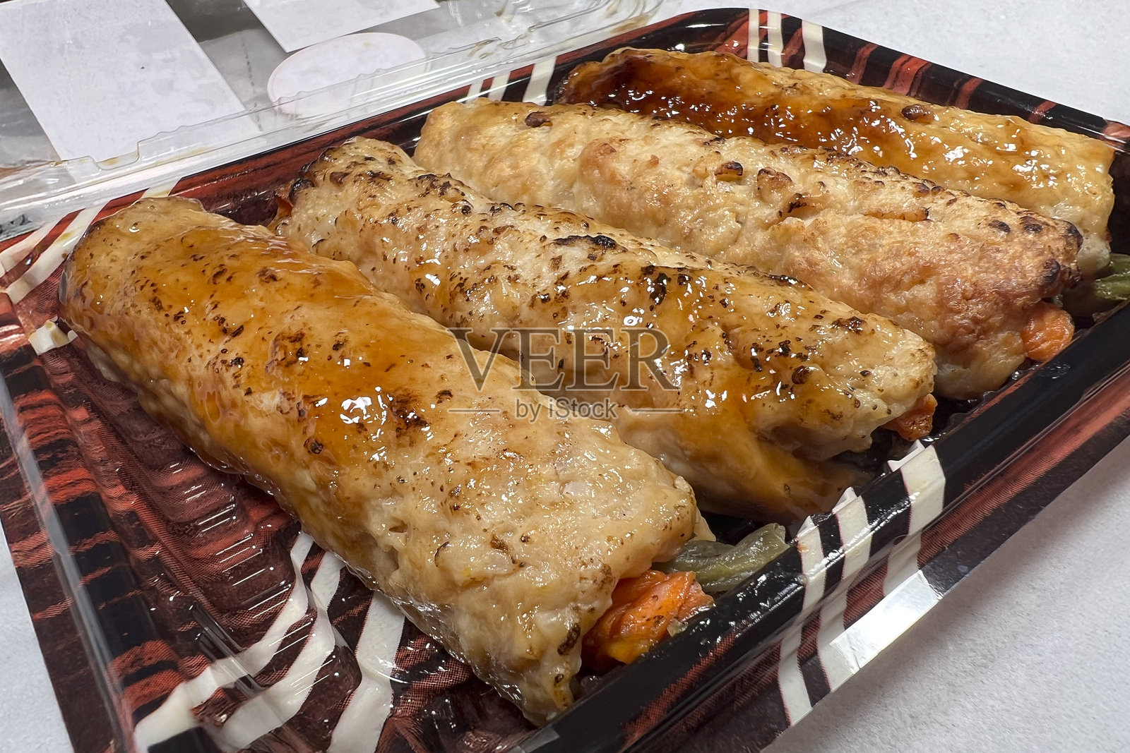 甜酱油 glaze 的烤鸡肉筑根卷配蔬菜照片摄影图片